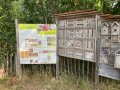 Insektenhotels und Schautafel vor Zaun