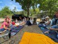 Personen sitzen auf Decken im Freien