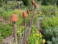 Holzstehlen mit tontöpfen in Garten