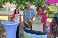3 Personen stehen an einem Stand