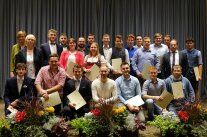 Gruppenbild der Personen vor Vorhang