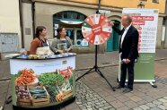 3 Personen stehen an einem Infostand