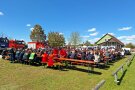 Menschenmenge auf Biertischgarnituren im Freien