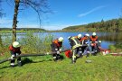 Feuerwehrleute legen Saugleitung in Weiher