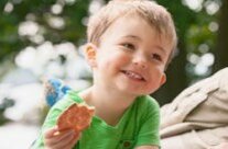 lächelnder Junge mit Keks in der Hand Getty Images